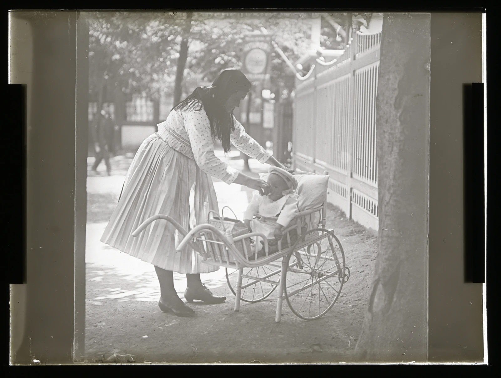 Iglauer Amme mit Kinderwagen vor einem Fahrgeschäft im Wiener Prater